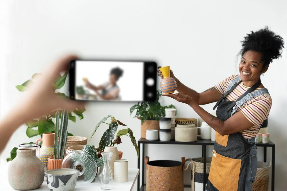 Small business owner filming a product video of handmade pottery for her online store