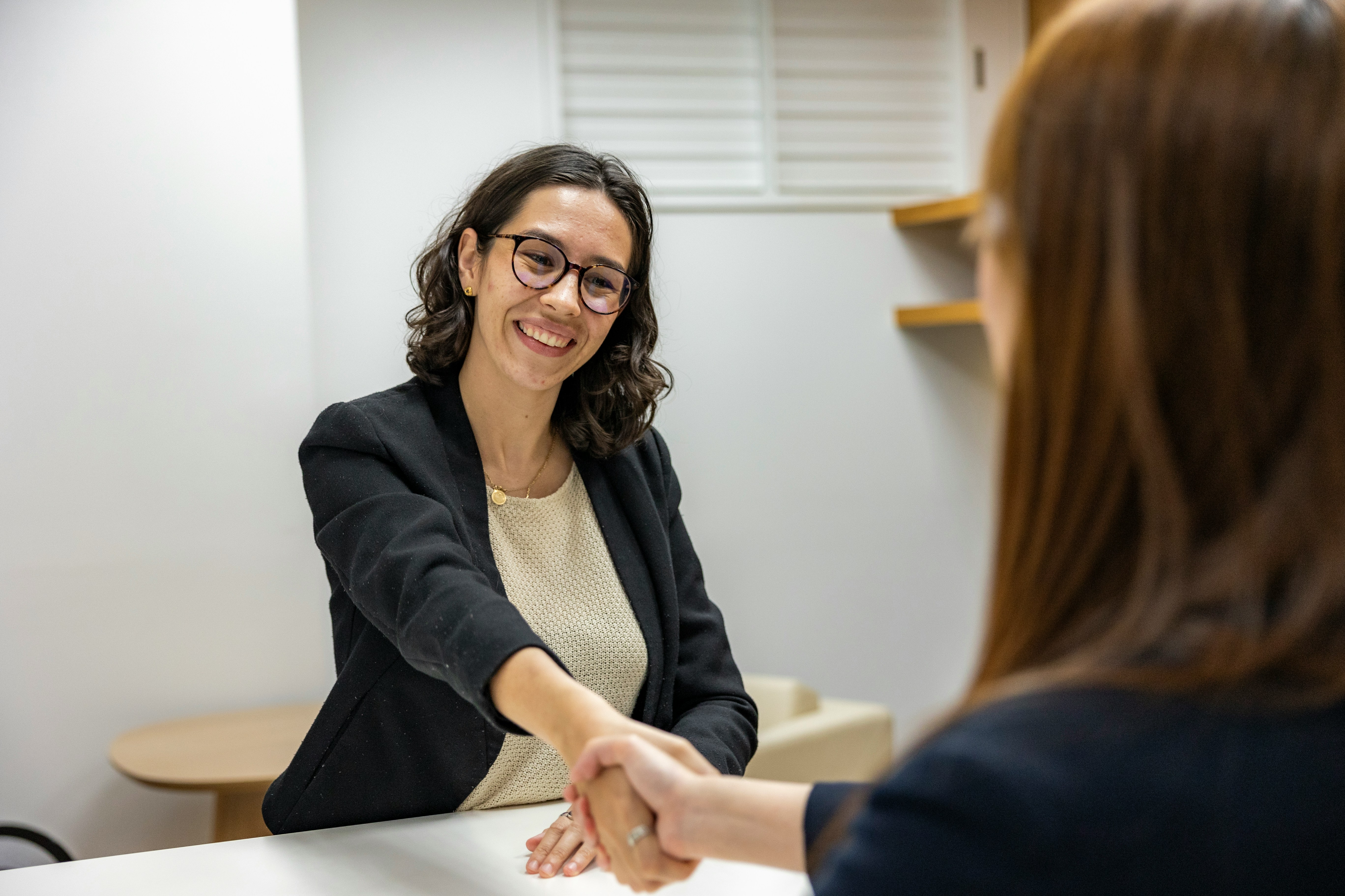 Two women shaking hands after a job interview, representing WordPress interview scheduling plugins