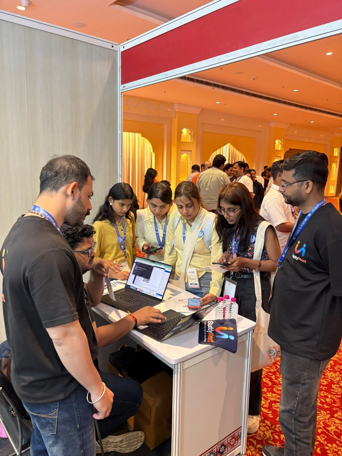 Students gathered around the BuddyNext booth at WordCamp Rajasthan 2026 watching a live demo and scanning a QR code